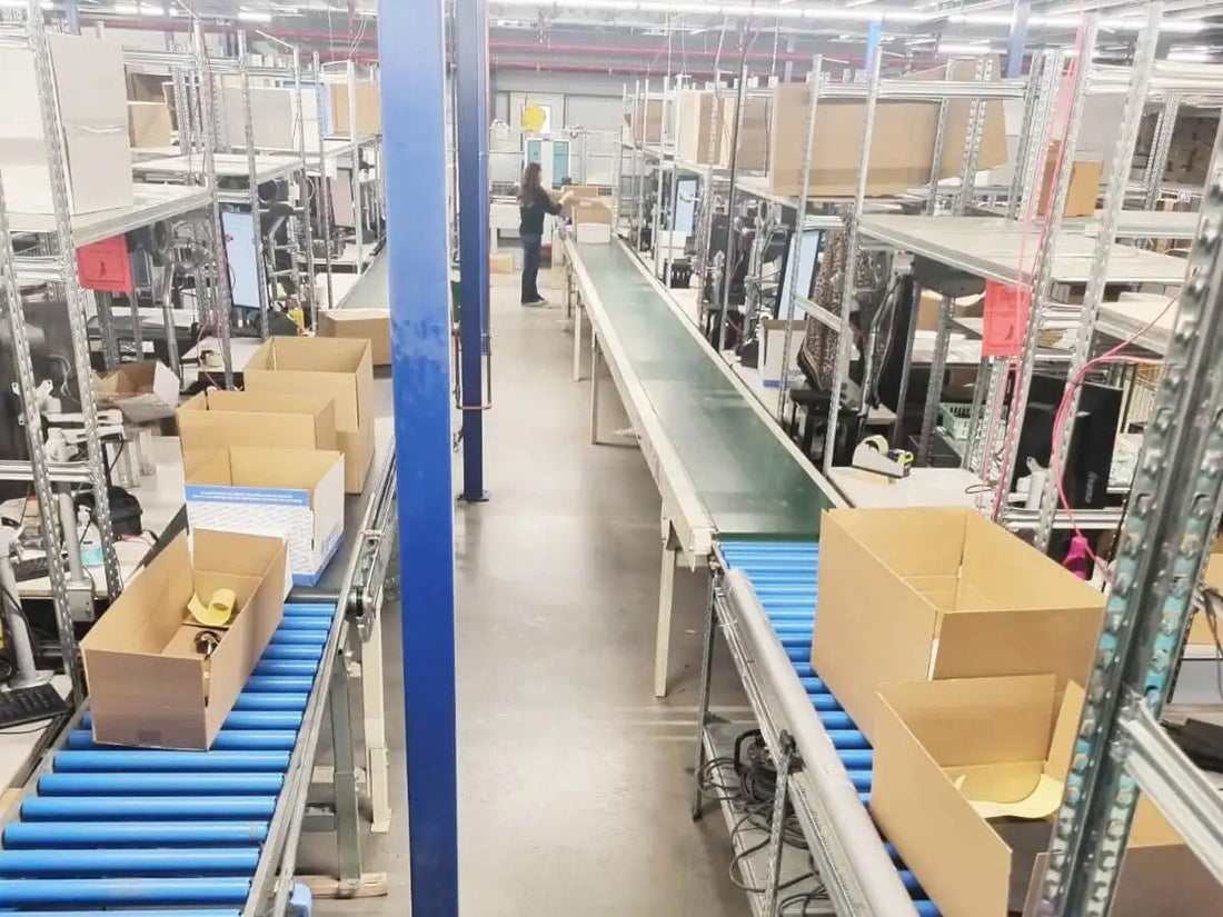 Blauwe rollende transportband met kartonnen dozen erop